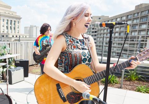 Outdoor performance with a singer-songwriter and a bassist. 