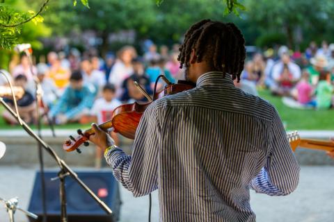 student playing violin at outdoor concert